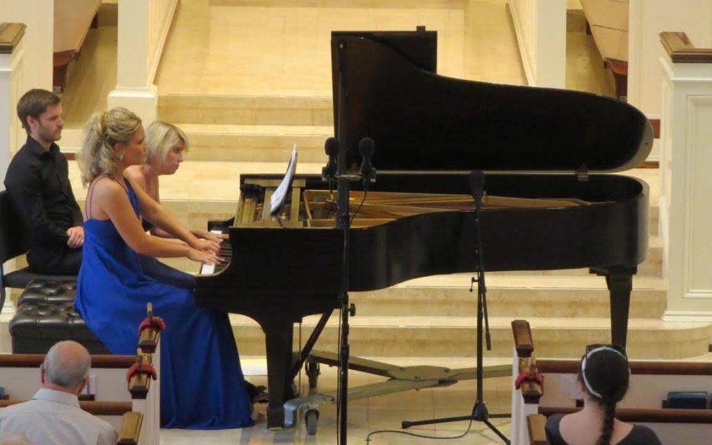 Julie Coucheron (left) and Elizabeth Pridgen perform the "four hands" piano piece. (Photo by Mark Gresham)